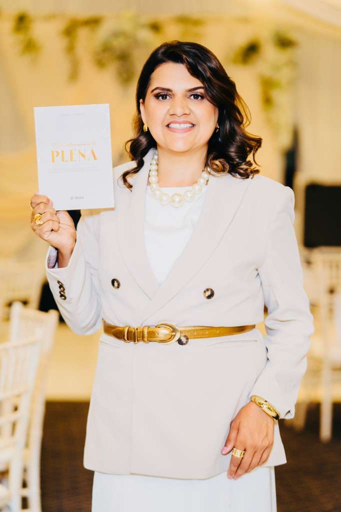 Denise Sampaio segurando o livro Extraordinariamente Plena